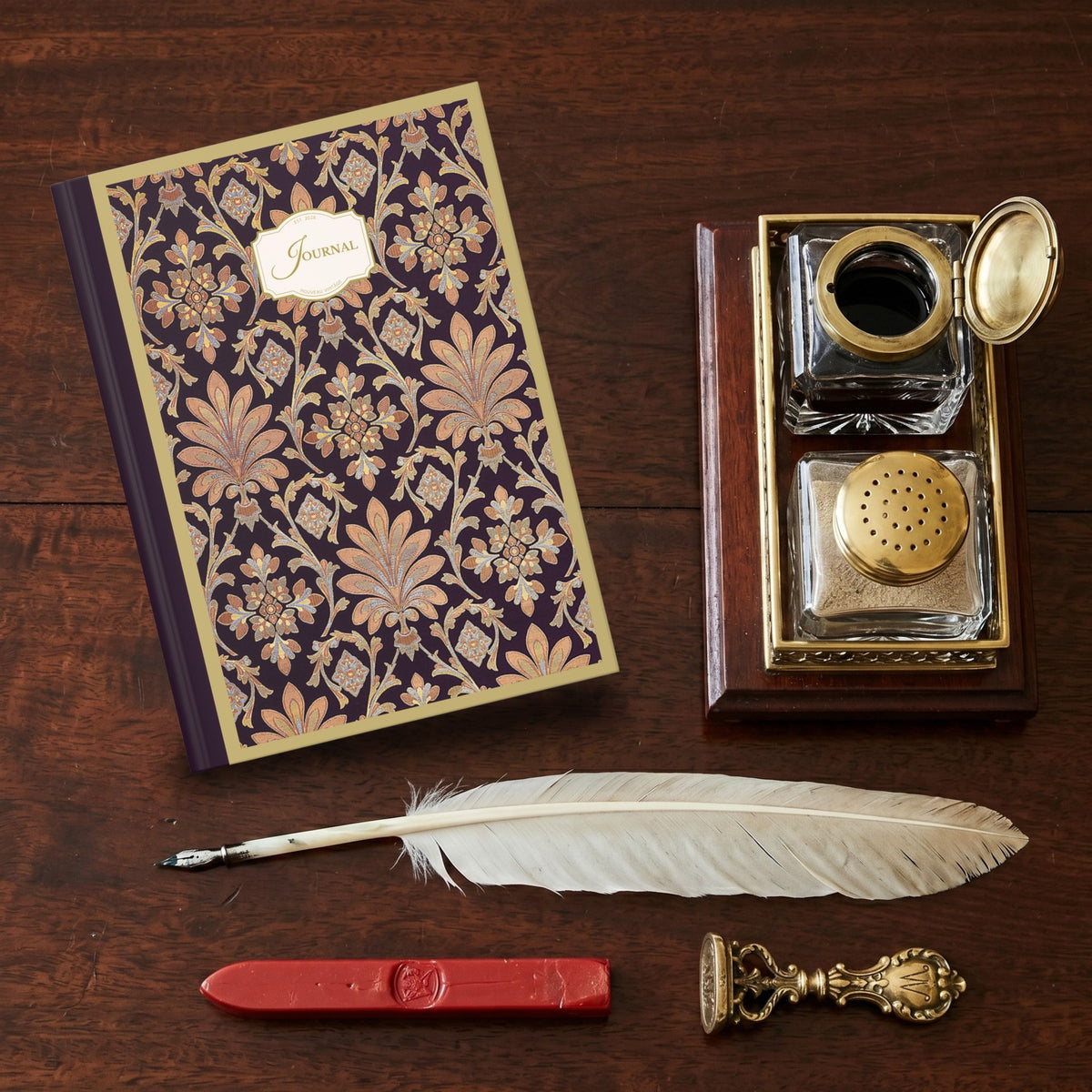 Decorative journal with inkwell set, feather pen, and sealing wax on a vintage wooden desk.