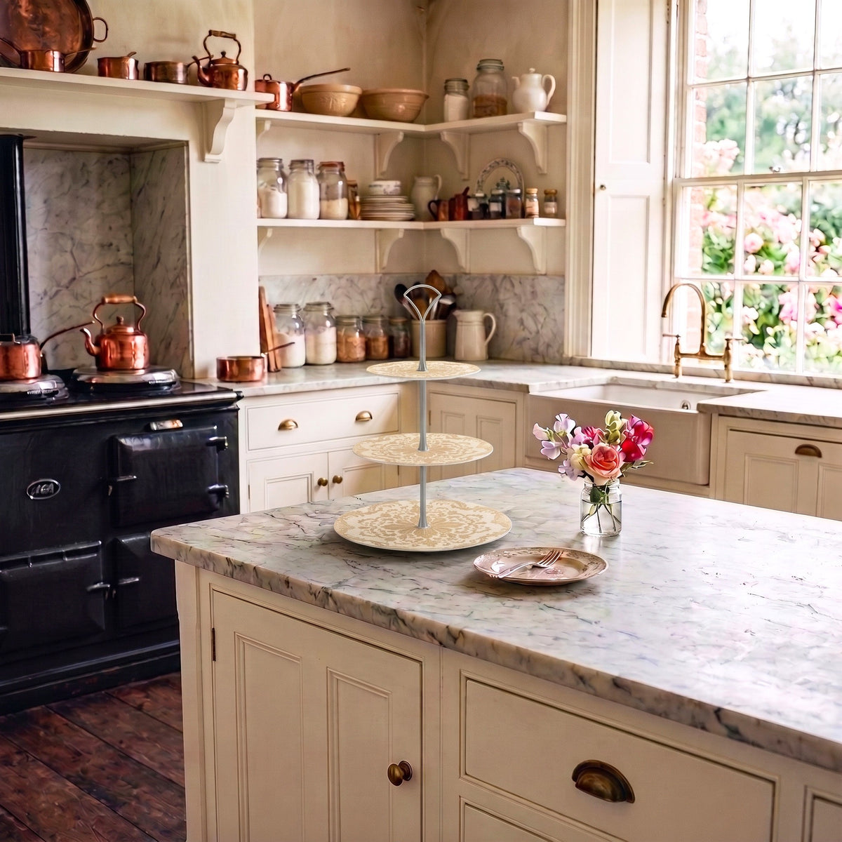 A decorative tiered cake stand sits on a marble bench in a classic vintage styled kitchen.