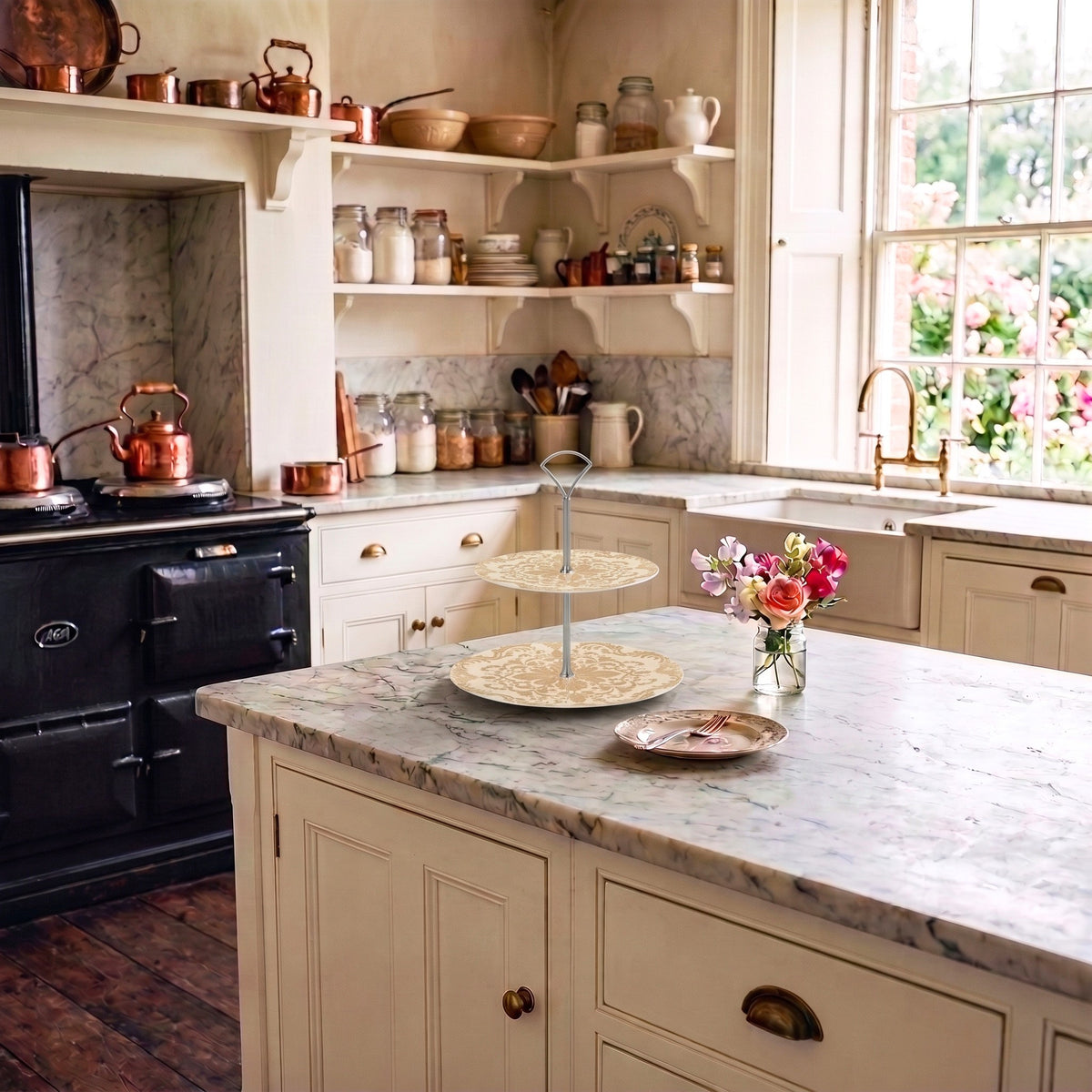 A decorative tiered cake stand sits on a marble bench in a classic vintage styled kitchen.