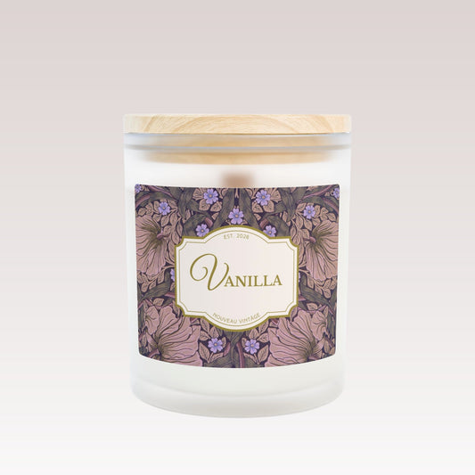 A close-up front view of a white candle in a frosted glass jar with a single wooden wick and wooden lid.